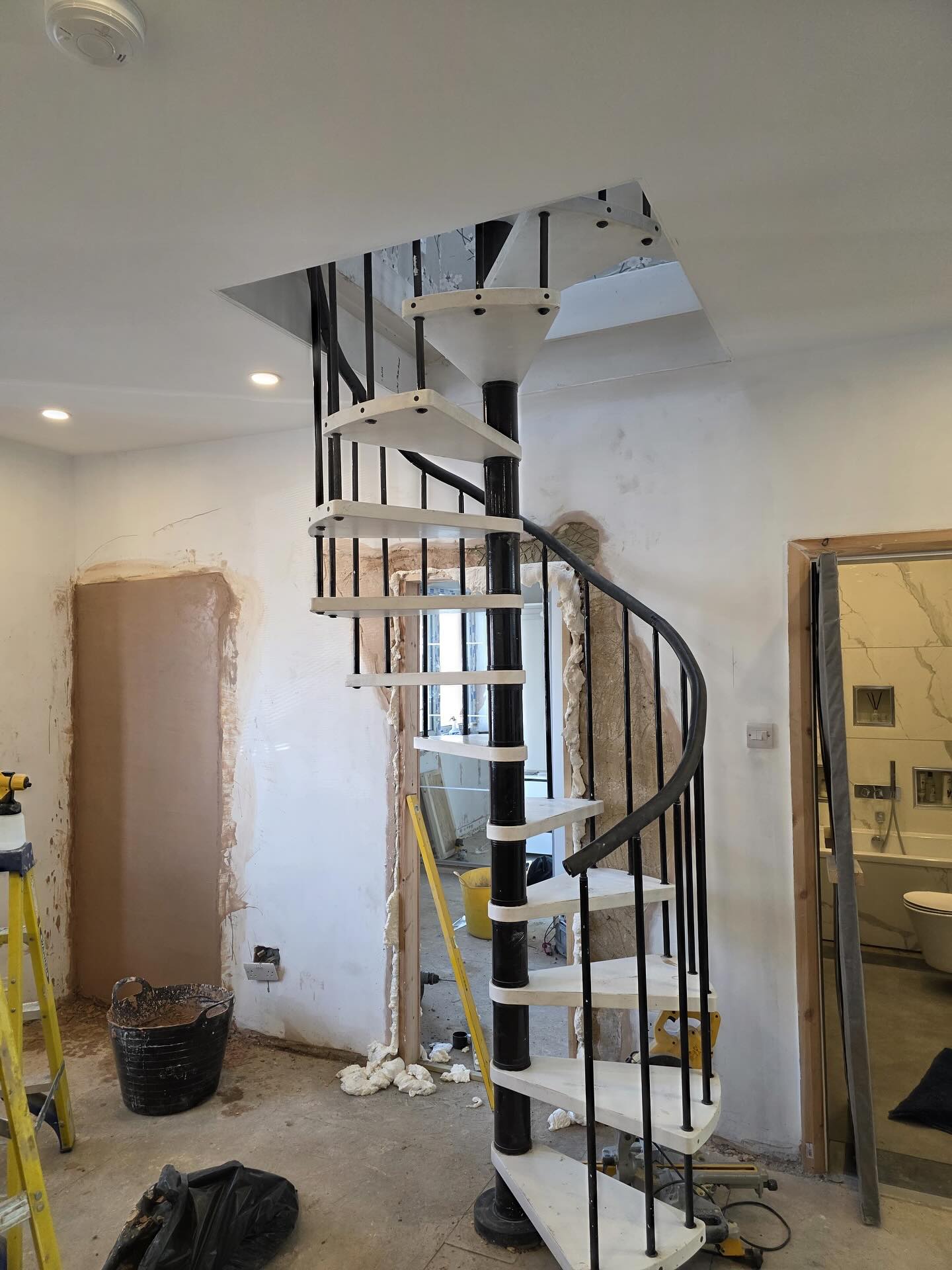 Spiral staircase with black metal handrail and white steps in Rochester, Kent